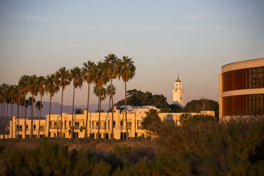 Sunset shot of LMU's dorms and Bell Tower with palm trees.